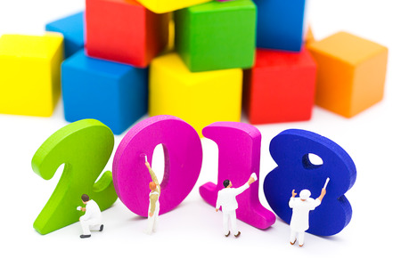 Miniature people: Workers are painting colorful number wood figures 2018 with colorful wooden is...
