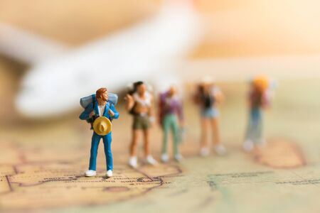 Miniature people: travelers with backpack standing on world map travel by plane Used as a travel business concept.の写真素材