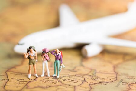 Miniature people: travelers with backpack standing on world map travel by plane Used as a travel business concept.の写真素材