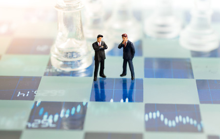 Miniature people, Two Businessmen standing on the chess game, thinking solution for the business game,  use as a business competition concept.の写真素材