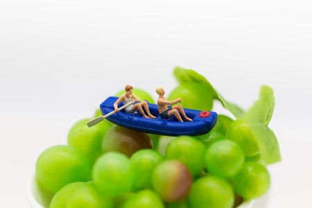 Miniature people : Travelers with paddle boat on the grape. Image use for activities, travel business concept.の写真素材