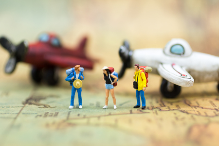 Miniature people: travelers with backpack standing on world map travel by plane. Image use for travel business concept.の写真素材