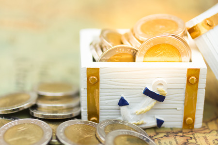The coins in the treasure chest on the map. Image use for business concept.の写真素材