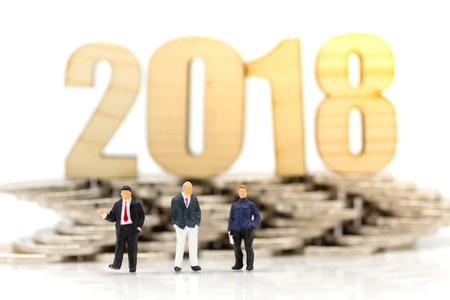 Miniature people : New Businessman in 2018, with coins. Image use for business concept.の写真素材