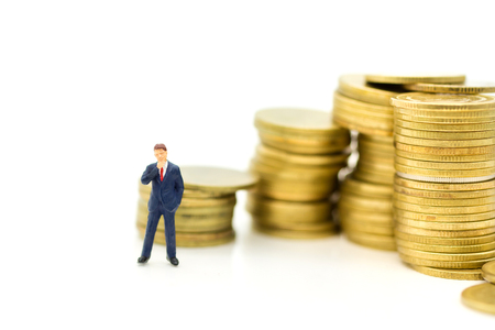 Miniature people: Businessman stand with stack of coins. Image use for background money growth up, saving, financial, business concept.の写真素材
