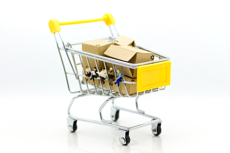 Miniature people: Group businessman sitting on shopping cart for retail business. Image use for online and offline shopping, marketing place world wide.の写真素材