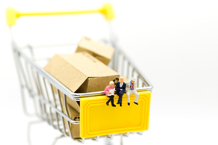 Miniature people: Group businessman sitting on shopping cart for retail business. Image use for online and offline shopping, marketing place world wide.の写真素材
