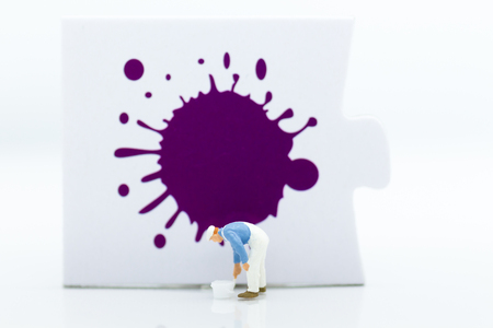 Miniature people: Workers are painting color on the puzzle. Image use for business concept.の写真素材
