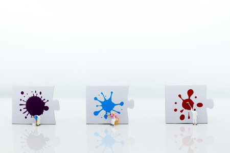 Miniature people: Workers are painting color on the puzzle. Image use for business concept.の写真素材