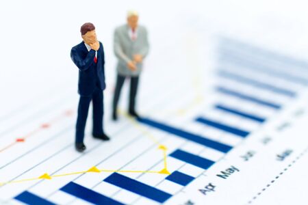 Miniature people: Businessman stand front of dashboard, display graphs, profit margins of ...