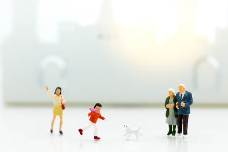 Miniature family: Boy is running with dog. Image use for Family day.の写真素材