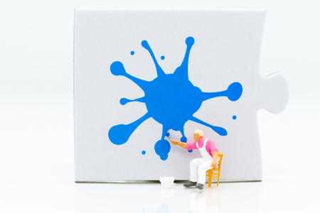 Miniature people: Workers are painting color on the puzzle. Image use for business concept.の写真素材