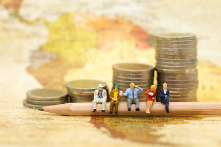 Miniature people : Businessman sitting on pencil with stack of coins . Image use for Business meeting concept.の写真素材