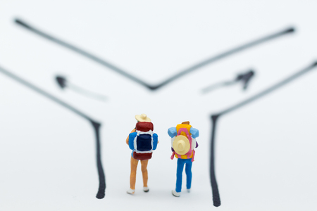 Miniature people : Backpacker walking follow arrow. Image use for travel, business concept.の写真素材