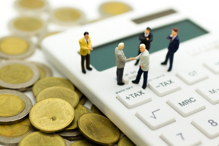 Miniature people: Businessman stand on calculator, calculation tax monthly/yearly. Image use for Tax calculation every year for everyone.の写真素材
