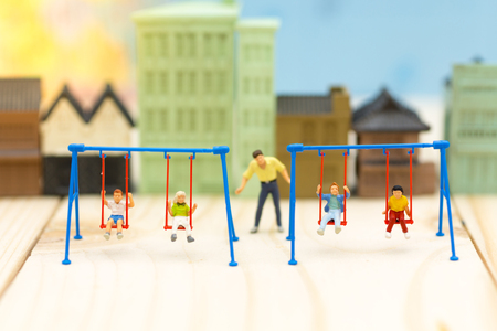 Miniature people : father swing cradle with children. Image use for background International day of families concept.の写真素材