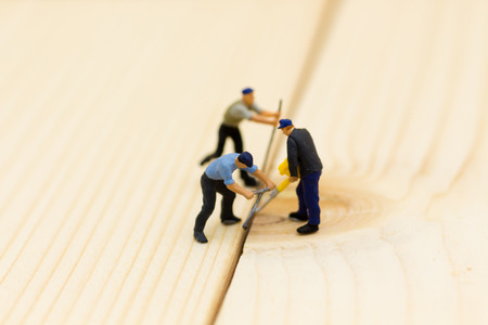 Miniature people: Workers are using wood punching equipment. Image use for construction work, business concept.の写真素材