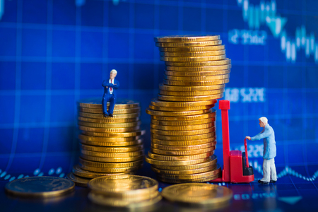 Miniature people: Worker use pallet truck with stack of coins. Image use for background business concept.の写真素材