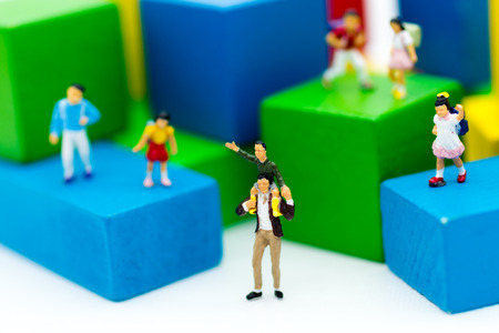 Miniature family: Father gave the son a ride on the neck and children stand around. Image use for expressed love between the family, the lineage.の写真素材