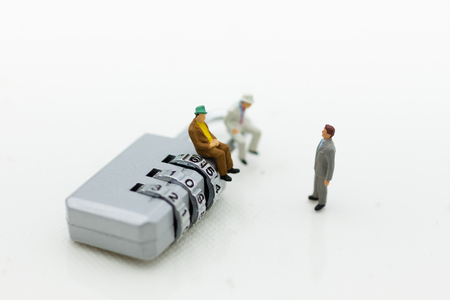 Miniature people:  Businessman sitting on master key encoding. Image use for background security system, hack, business concept.の写真素材
