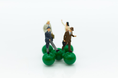 Miniature people : Businessman group standing on green toy. Image use for teamwork, business concept.の写真素材