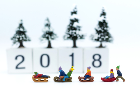 Miniature people: Children playing on snow funny together. Image use for Christmas festivalの写真素材