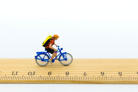 Miniature people: Tourists cycling on ruler . Image use for distance of travel, business concept.の写真素材