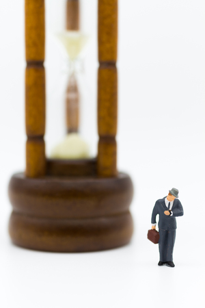 Miniature people: Businessman with hourglass. Image use for time of business concept.の写真素材