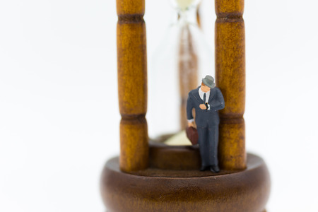 Miniature people: Businessman with hourglass. Image use for time of business concept.