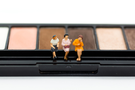 Miniature people: Women sit on a eyeshadow palette for makeup. Image use for cosmetic, beautiful conceptの写真素材