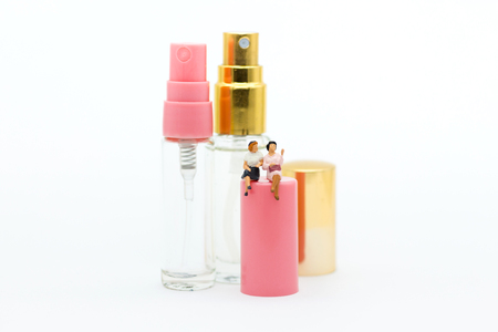 Miniature people: Women sit on perfume spray. Image use for cosmetic, beautiful concept.の写真素材