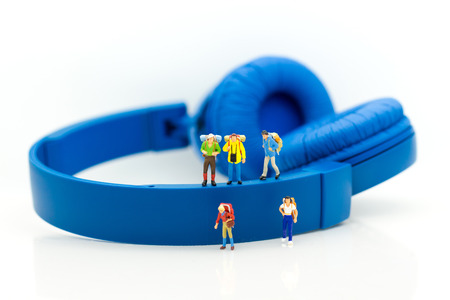 Miniature people: Travelers walking on the headphones. Image use for vacation, relax time, holiday concept.の写真素材