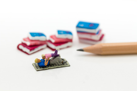 Miniature people : Father and son playing on floor with book and pencil. Image use for education , prepare to study concept.の写真素材