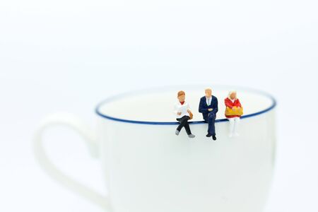Miniature people : Business team sitting on cup of coffee and having a coffee break. Image use for business concept.の写真素材
