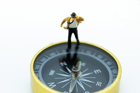Miniature people: Businessman standing on compass. Image use for direction of business.の写真素材