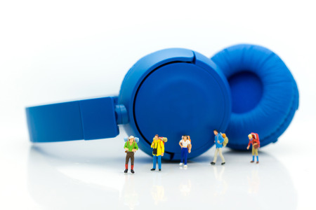 Miniature people: Travelers walking on the headphones. Image use for vacation, relax time, holiday...