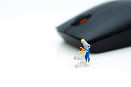 Miniature people: Shoppers and shopping cart with mouse. Image use for shopping online, solution for buy product via network internet.の写真素材