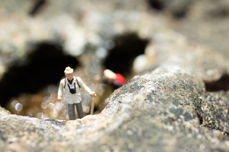 Miniature people, backpackers walking on the stones at beach. Image use for travel Lifestyle adventure vacations concept.の写真素材
