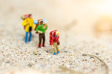 Miniature people: travelers with backpack walking on the beach. Image use for travel, vacation concept.の写真素材