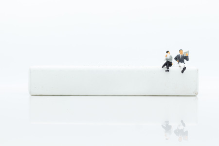 Miniature businessman sitting on white block, it can write for various occasions. Image use for...