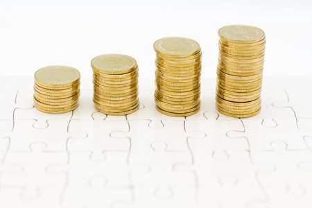 Stack of golden coins on jigsaw board. Image use for investment, business background concept.