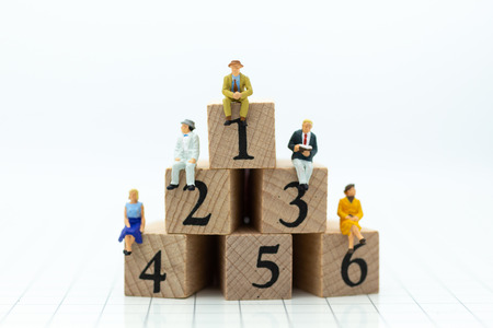 Miniature people : Businessman sitting on wooden blocks with sequential numbers. Image use for business concept.の写真素材