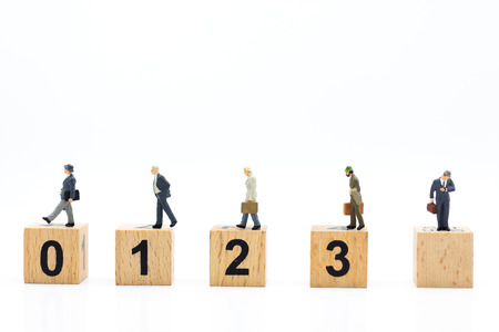 Miniature people : Businessman standing on wooden blocks with sequential numbers. Image use for...