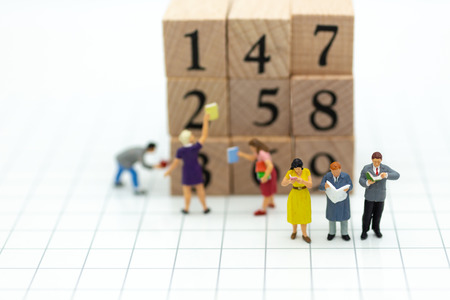 Miniature people: businessman reading book with wooden block. Image use for background education or business concept.の写真素材