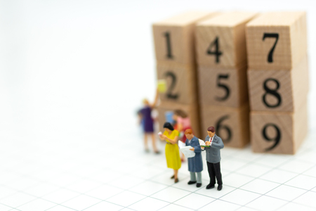 Miniature people: businessman reading book with wooden block. Image use for background education or business concept.の写真素材