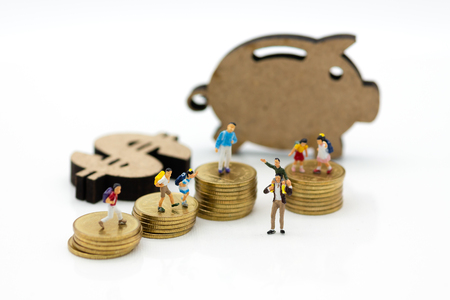 Miniature people: Children group with Piggy bank standing and stack of coins. Image use for investment, saving money.の写真素材