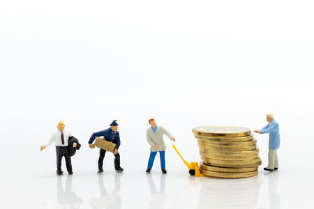 Miniature people: Worker use pallet truck with stack of coins. Image use for background business concept.の写真素材