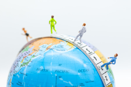Miniature people running on waistline with world map . Image use for healthy , exercise concept.