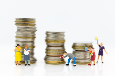 Miniature people: Students read books, keep books on bookshelves with stack of coins . Image use for...