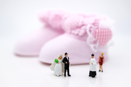 Miniature people : Bride and groom wear wedding suit and waiting for baby in the future . Image use for make new family.の写真素材